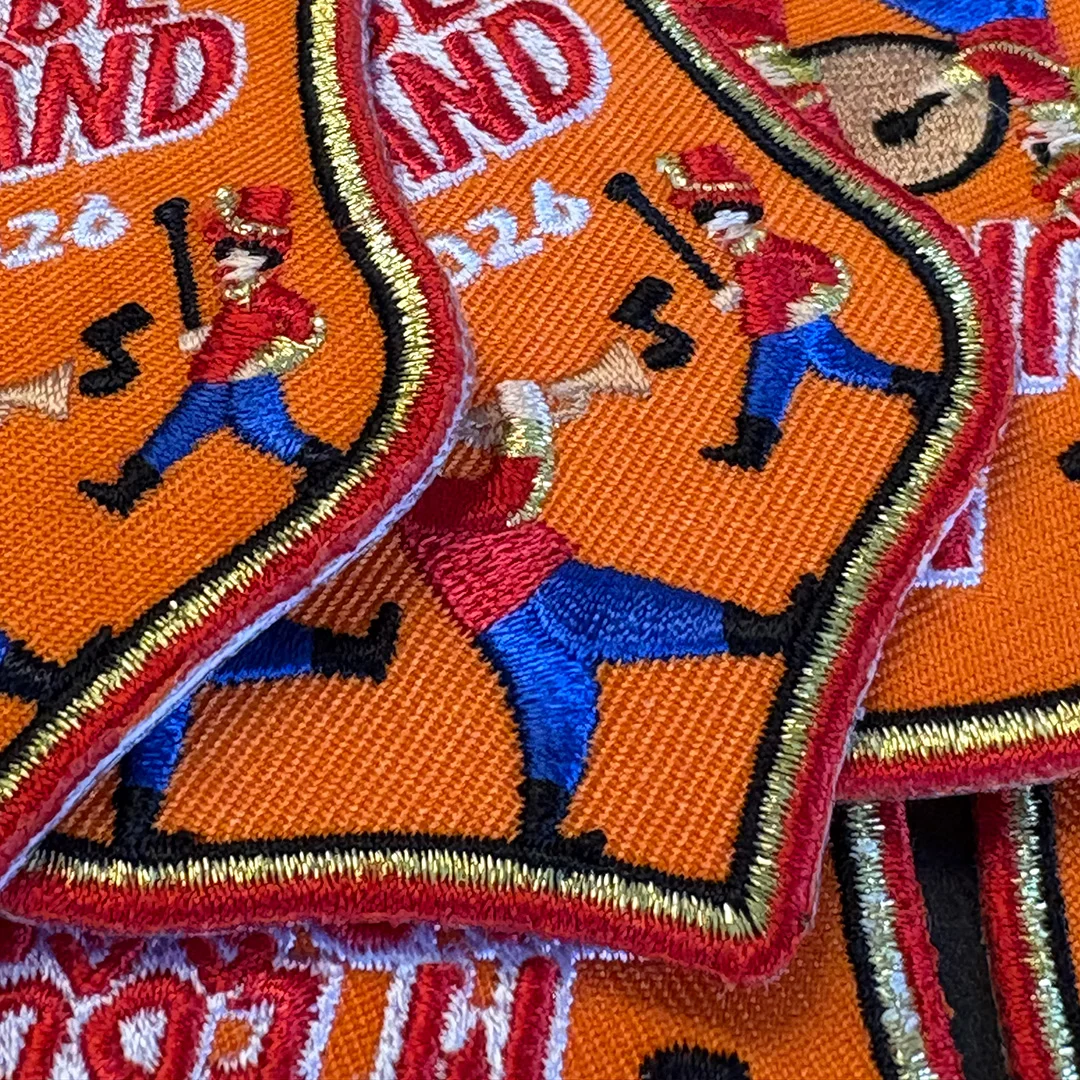 M'ebbe un b&acirc;&acirc;nd - Motto 2026 - Mottoembleemkielegat2026 - IN058-12